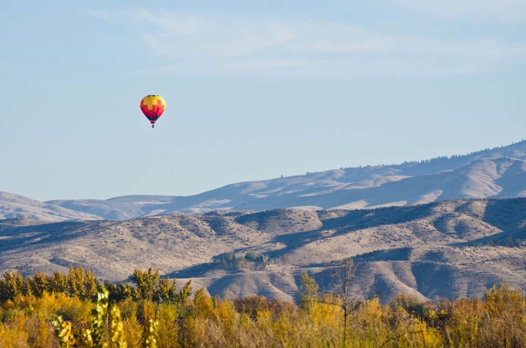 Hot Air Balloon Flying Over The Foothills